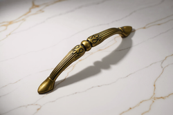 Image of Decorative brass handle on a marble surface